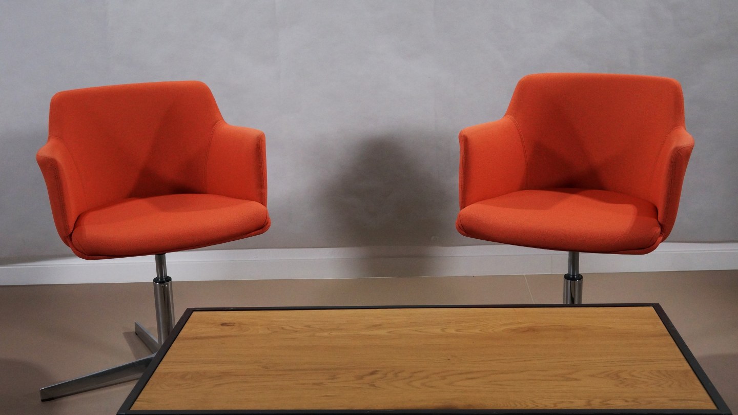 Deux fauteuils orange face à face prêts pour un entretien