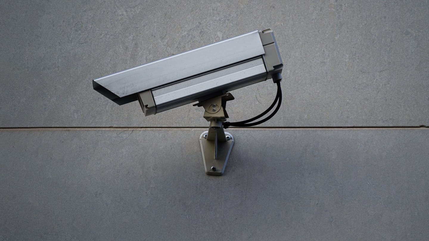 Caméra de vidéosurveillance fixée sur un mur gris