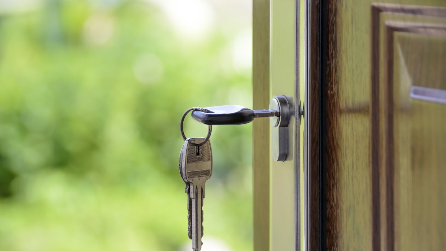 Clés insérées dans la serrure d'une porte en bois